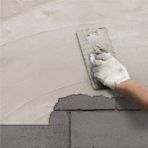 Trainee applying One Coat Render (OCR) on exterior rendering training bay in Yorkshire